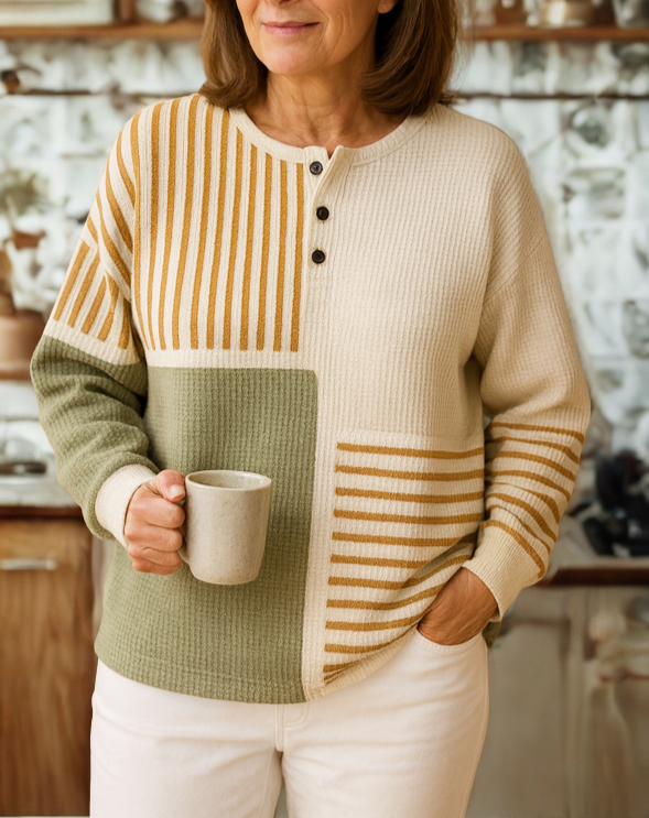 Woman wearing a waffle knit colorblock henley top with cream, sage green, and striped panels, featuring a three-button neckline and relaxed fit._1