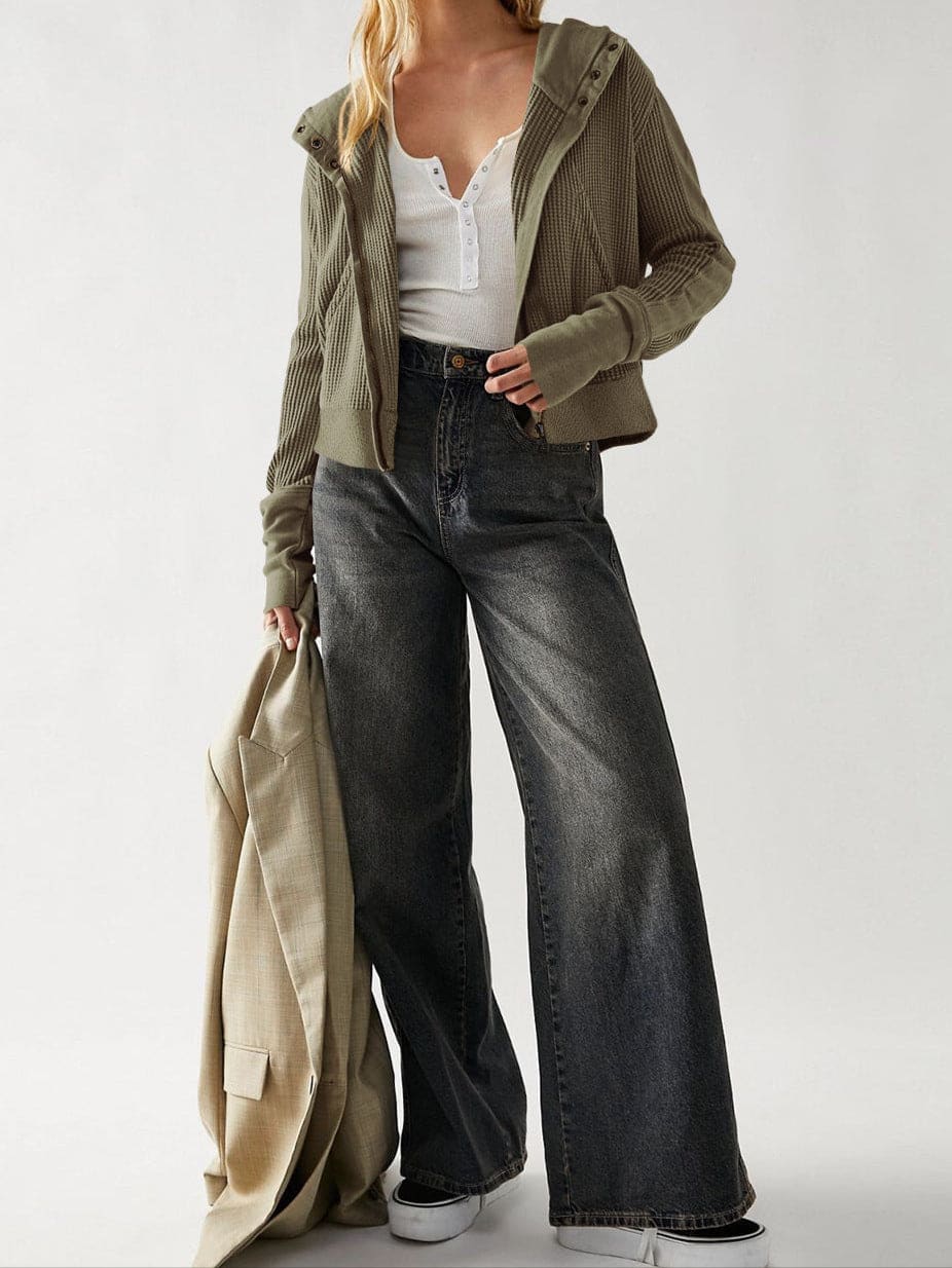Model wearing an olive green waffle knit zip-up hoodie with cropped length and hood, styled with brown pants._22