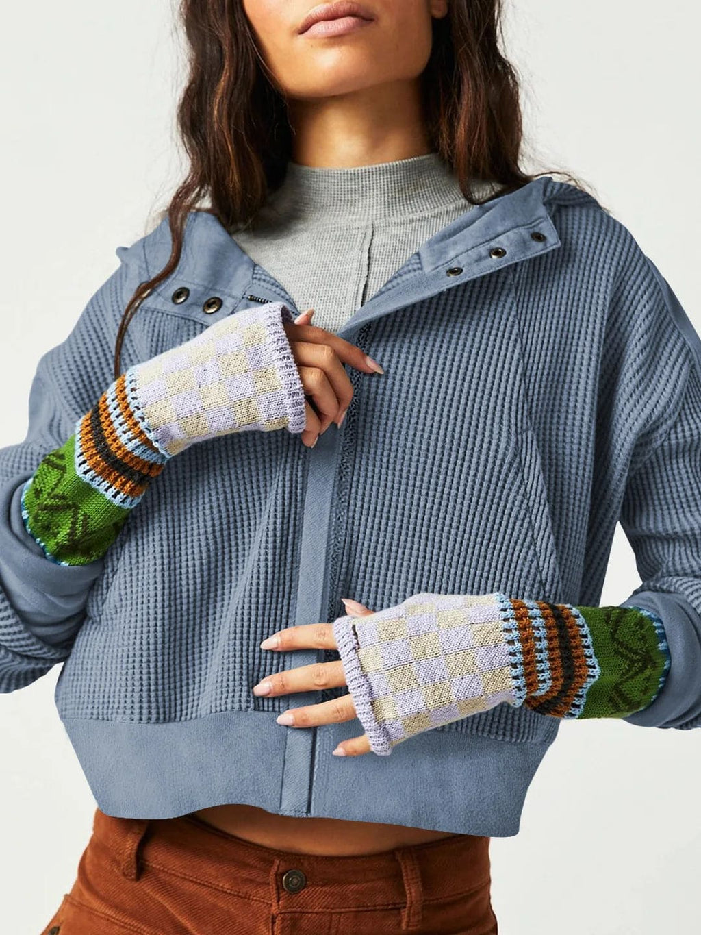 Model wearing an olive green waffle knit zip-up hoodie with cropped length and hood, styled with brown pants._23