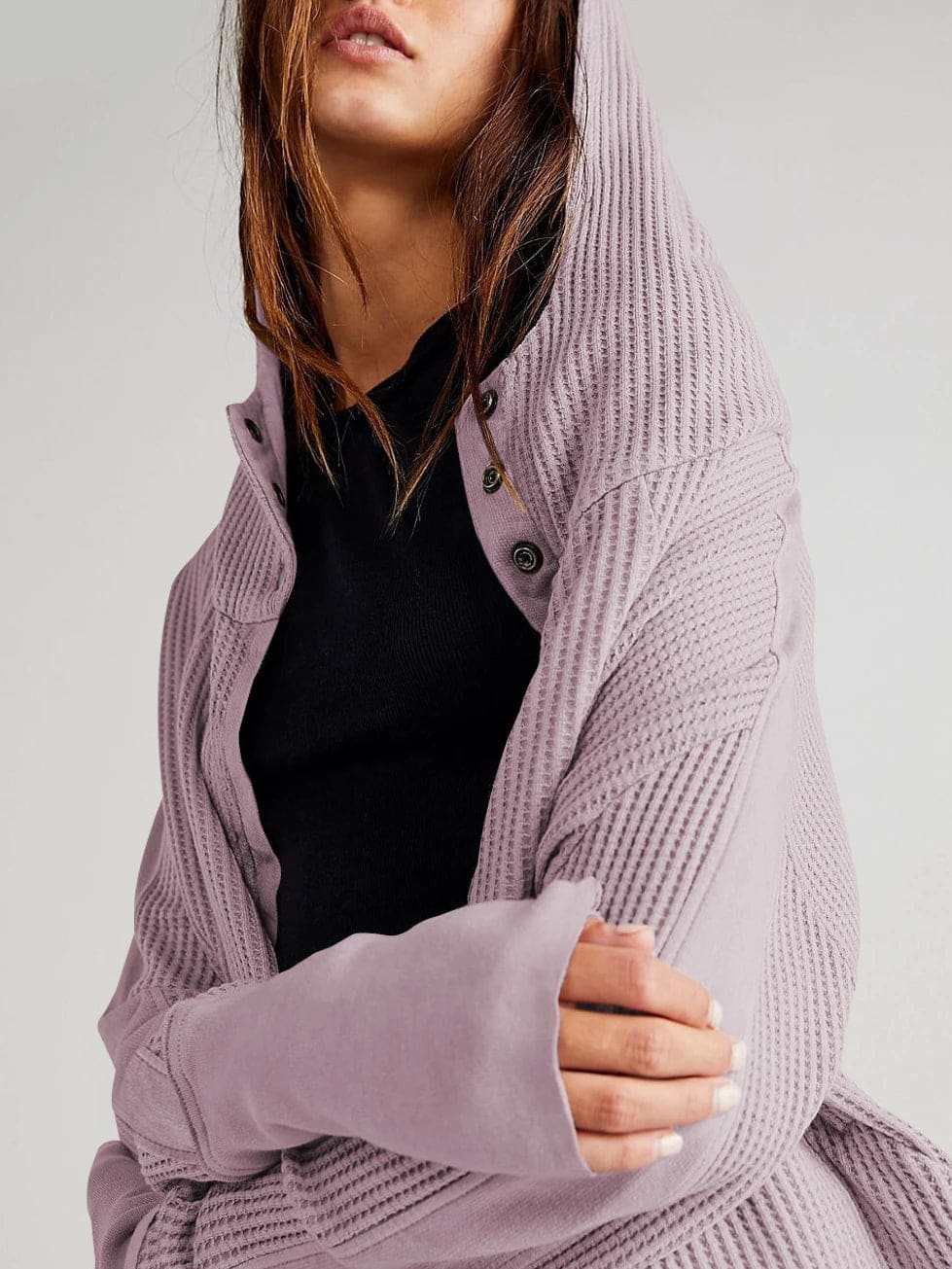 Model wearing an olive green waffle knit zip-up hoodie with cropped length and hood, styled with brown pants._39
