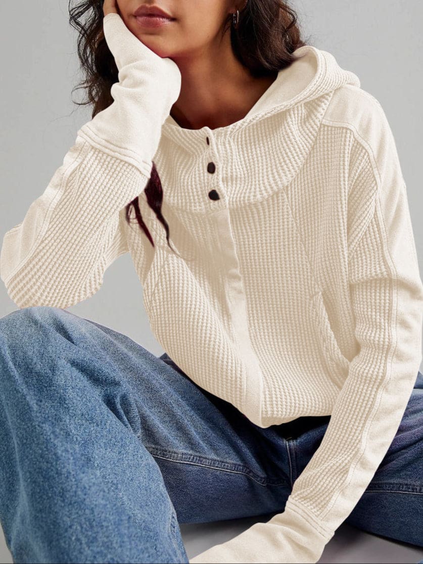 Model wearing an olive green waffle knit zip-up hoodie with cropped length and hood, styled with brown pants._48