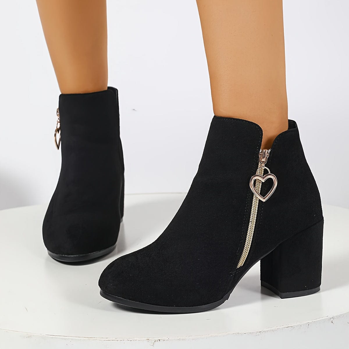 Pair of ankle boots with block heel, side zipper with gold heart charm, and elastic panel for easy wear._2