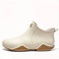 Side view of a slip-on ankle boot in a neutral tone with a contoured sole and pull tab at the heel._0