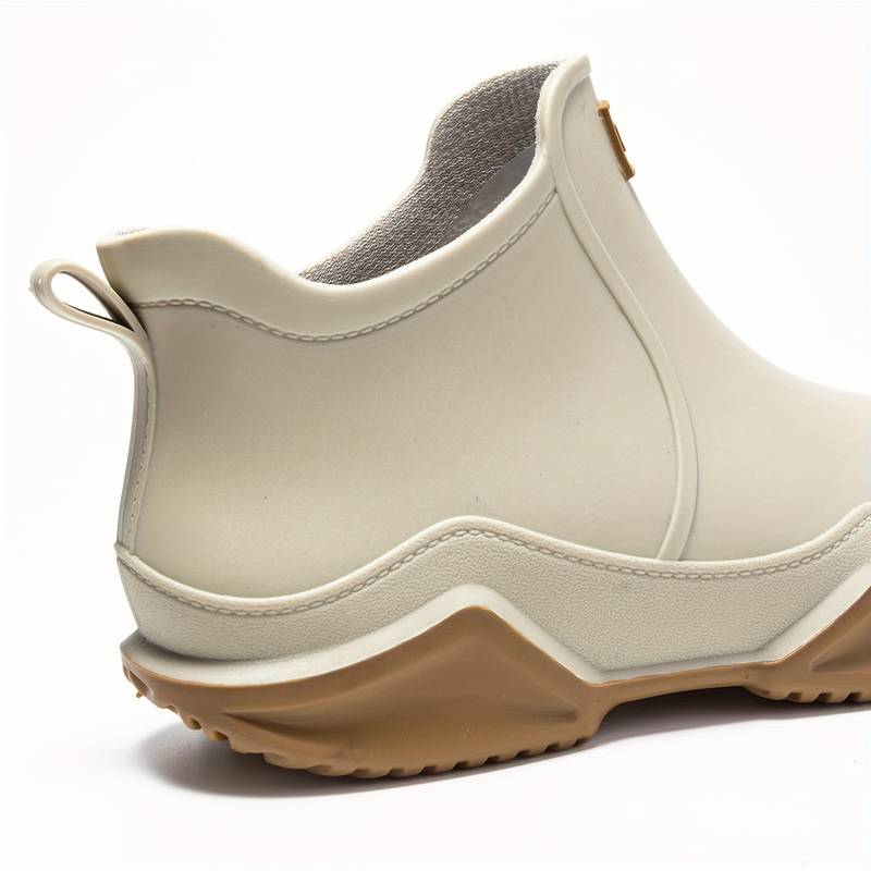 Side view of a slip-on ankle boot in a neutral tone with a contoured sole and pull tab at the heel._8