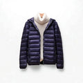 A hooded quilted puffer jacket with a front zip closure is shown layered over a light turtleneck._0