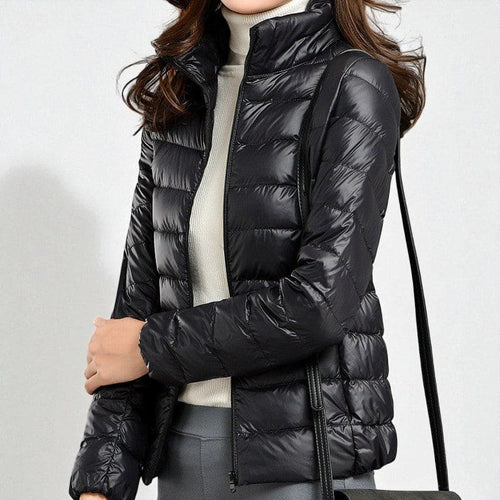 A quilted puffer jacket with a high collar and front zip closure shown layered over a sweater._3