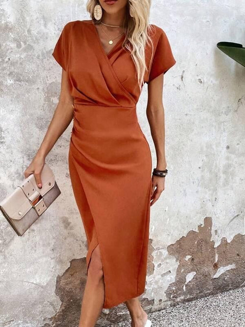 Woman wearing a rust orange wrap midi dress with v neckline and short sleeves, styled with statement earrings and a clutch_1